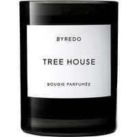 Black glass Byredo Tree House candle with white label and bold black text.