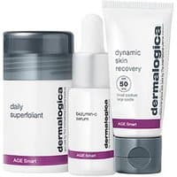 Dermalogica Age Defense Kit with daily superfoliant, biolumin-c serum, dynamic skin recovery SPF 50 in white bottles.