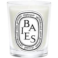 Clear glass Diptyque Baies candle with black lettering and white wax, featuring a classic oval label design.