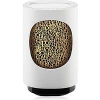 White Diptyque electric diffuser with black base, featuring a gold lattice design on the front panel.