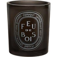 Dark glass Diptyque Feu de Bois candle with white oval label and black text, 300 g, woody scent.