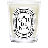 Diptyque Gardenia candle in clear glass with black and white label, featuring floral scent description.