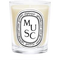 Diptyque Musc Candle in clear glass holder with black and white label featuring "MUSC" text.