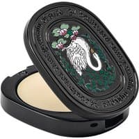 Black oval compact with embossed swan design, containing Diptyque Ombre dans l'Eau unisex floral solid perfume.