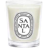 Diptyque Santal candle in clear glass jar with black and white label, featuring woody fragrance text.