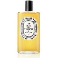 Amber liquid in clear bottle with white label, black text, and Diptyque branding, "Vinaigre de Toilette 80".