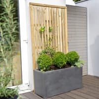 Vertical slatted garden screen panel, 6' x 3', pressure-treated wood, beside a planter with green shrubs.
