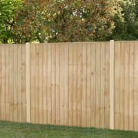 Pressure-treated vertical closeboard fence panel, natural wood finish, 6' x 5'6, with sturdy posts and lush greenery backdrop.