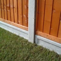 Forest lightweight concrete gravel board, 6'x6", gray with textured surface, installed under wooden fence panel.