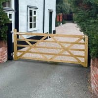 Wooden Forest Croft Prestige gate, 8'x4', with diagonal cross-bracing, natural finish, set between brick pillars.
