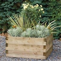 Square wooden raised bed with interlocking panels, filled with various green plants and yellow flowers.