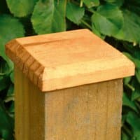 Wooden Forest Fence Post Cap 13 x 13cm with beveled edges, natural finish, atop a square post against green foliage.