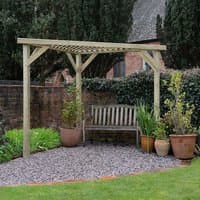 Wooden corner pergola with slatted roof, natural finish, over a garden bench, surrounded by potted plants.