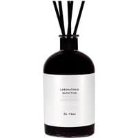 Dark glass bottle diffuser with white label, black reeds, and "Laboratorio Olfattivo - Di-Vino" text.