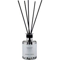 Clear glass diffuser bottle with black reeds, silver cap, and white label, "Giardino d'Inverno" by Laboratorio Olfattivo.