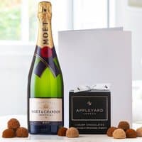 Moët & Chandon Brut Champagne bottle, black box of 12 chocolate truffles, and a white occasion card.