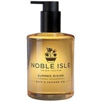 Clear bottle of Noble Isle Summer Rising Bath & Shower Gel with black pump and floral logo, 250 ml.