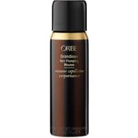 Black and gold Oribe Grandiose Hair Plumping Mousse, travel size canister, sleek design for volume and styling.