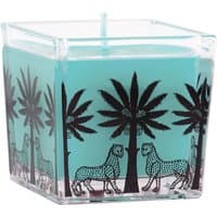 Turquoise Ortigia Florio square candle with black palm and animal design on clear glass holder.