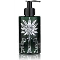 Dark green Ortigia Melograno body cream bottle with black pump, featuring white palm tree and leopard design.