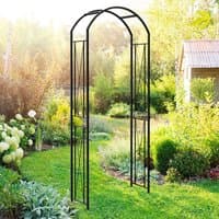 Black metal garden arch with curved top and decorative side panels, set in a lush garden setting.