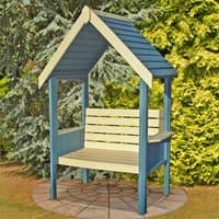 Blue and cream wooden garden arbour seat with slatted backrest, peaked roof, and side panels on a stone patio.