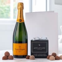 Veuve Clicquot Yellow Label Brut Champagne, 12 chocolate truffles in black box, and a white occasion card.